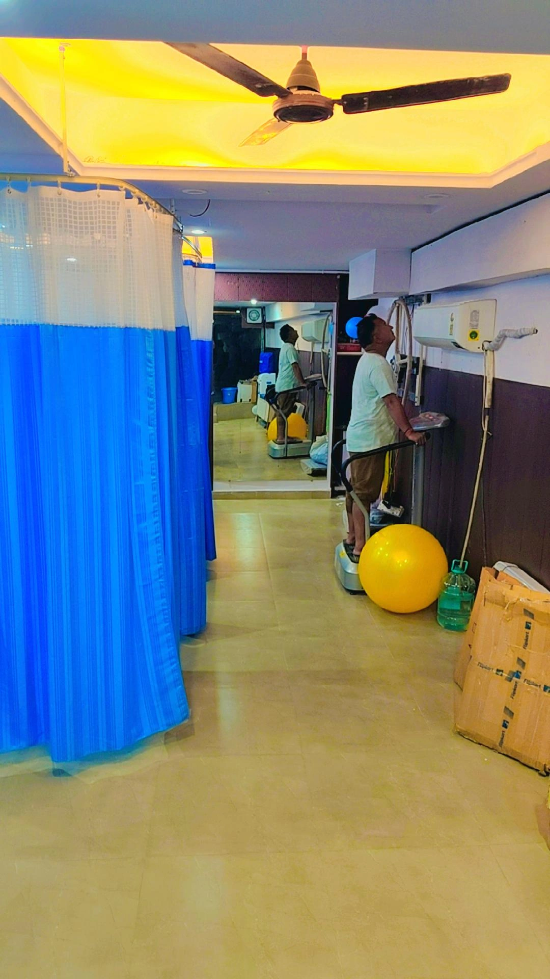 NeoMotion PhysioTherapy treatment room with exercise equipment and privacy curtains